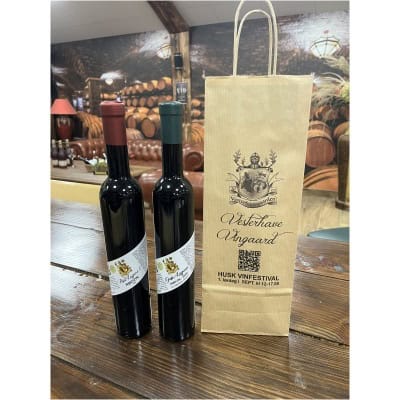 Røde vine fra Vesterhave Vingaard, på en rustik træbord, til vinfestival.