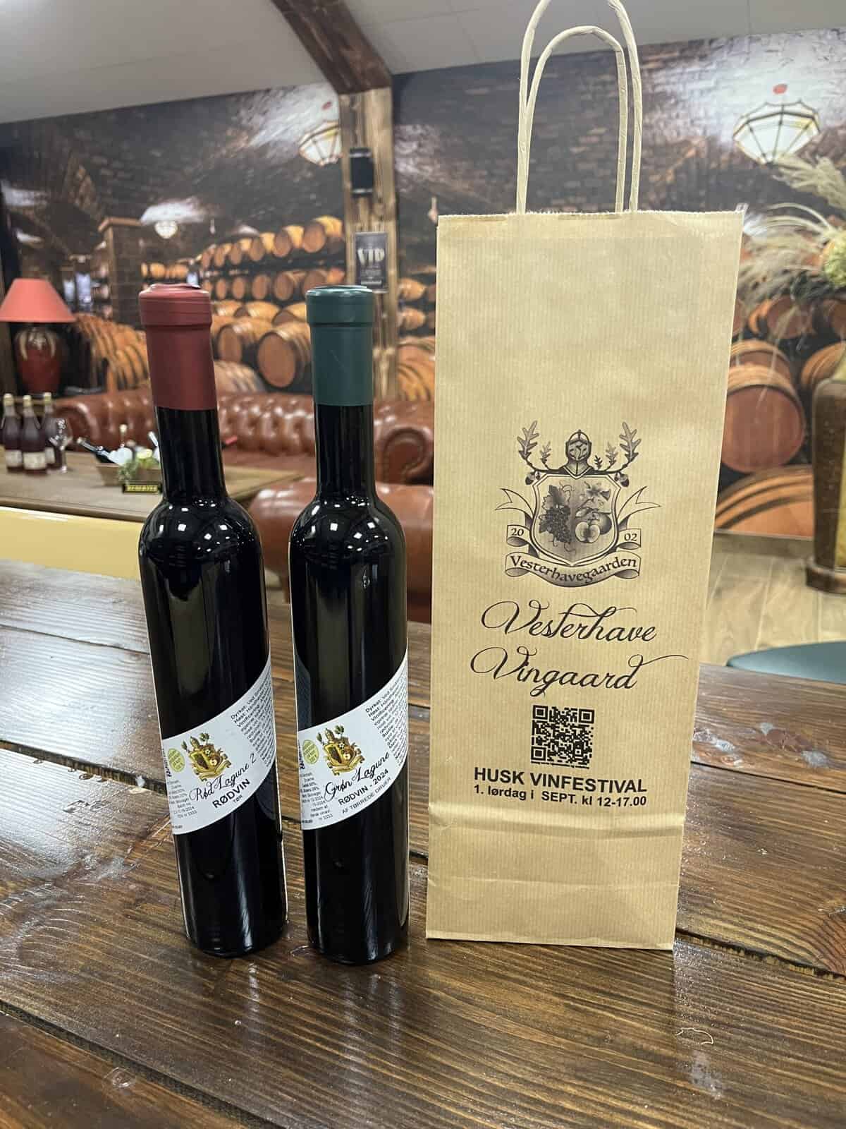 Røde vine fra Vesterhave Vingaard, på en rustik træbord, til vinfestival.