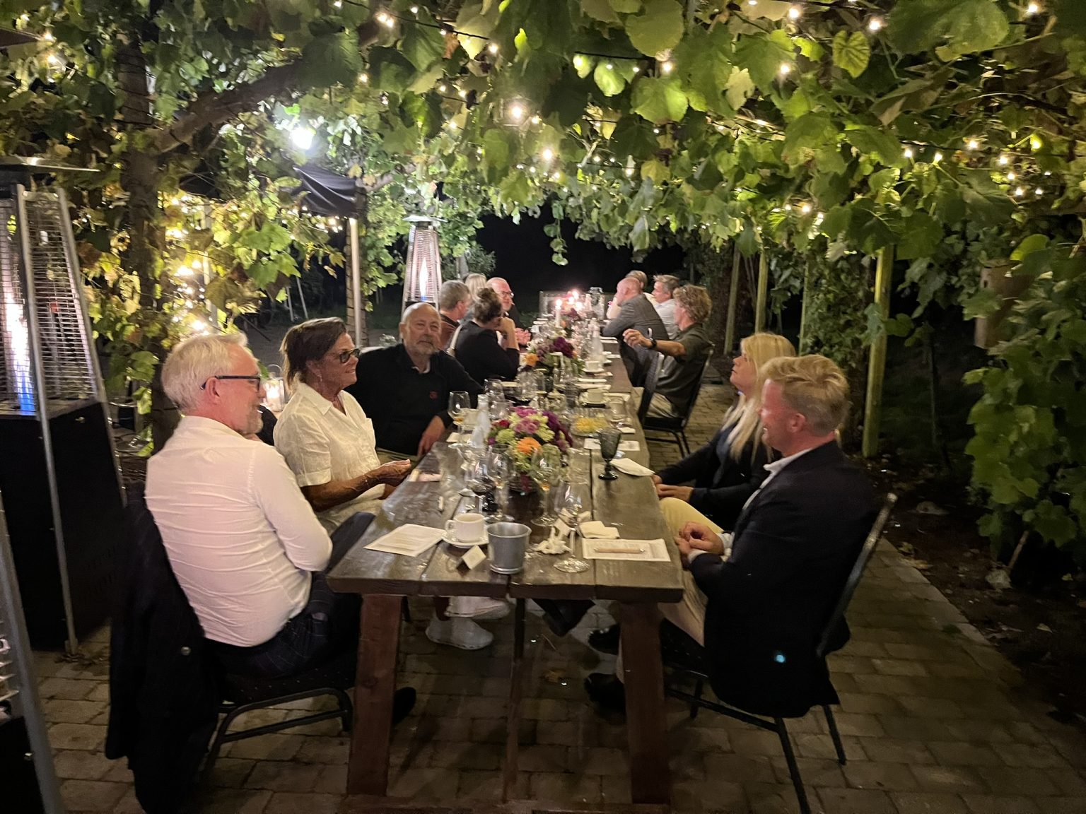 Langbord dækket med vin og blomster til en fest på Vesterhave Vingaard