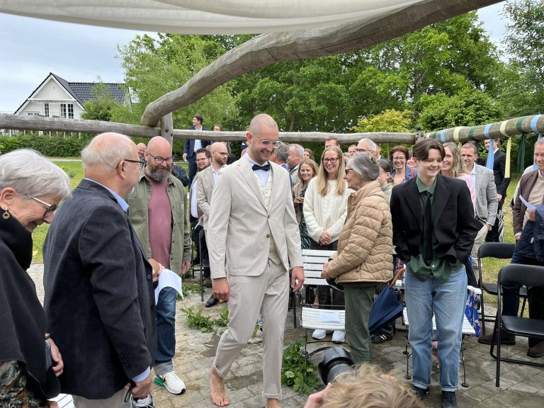 Gommen går op ad midtergangen til udendørs vielse på Vesterhave Vingaard